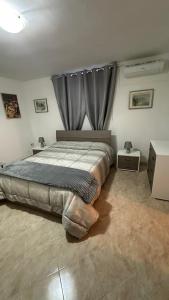 een slaapkamer met een groot bed en een gordijn bij B&B Mamma Mia s in Airola