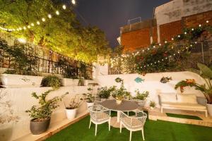 een patio met een tafel, stoelen en planten bij Hostal Bonanza in Sitges