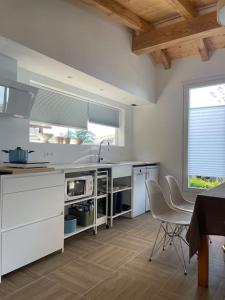una cocina con electrodomésticos blancos, mesa y sillas en Monte y playa junto al mar, en Mutriku