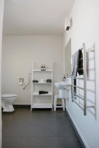 a white bathroom with a sink and a toilet at Amber Court Motel Nelson in Nelson