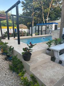 a swimming pool with a table and some plants at Tropicoco Pool House Steps From The Beach in Puerto Nuevo