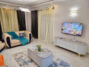 ein Wohnzimmer mit einem Sofa und einem Flachbild-TV in der Unterkunft Mellow Homes 3 - Own compound in Kitengela 