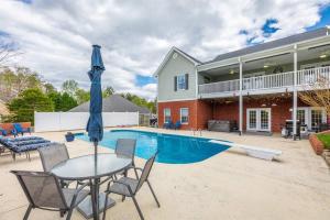 a house with a swimming pool and a table with an umbrella at Pickleball - Pool - Hot Tub - Gym - BBQ in Cenchat
