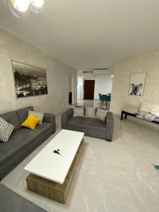 a living room with two couches and a coffee table at Tala bay apartments 2 bedroom in Aqaba