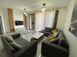 a living room with two couches and a table at Tala bay apartments 2 bedroom in Aqaba