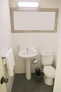 a white bathroom with a sink and a toilet at Low Cost Hoteles in Piura
