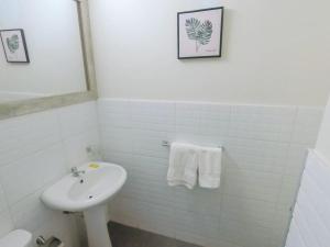 bagno bianco con lavandino e servizi igienici di Low Cost Hoteles a Piura