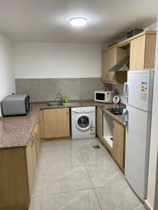 a kitchen with a white refrigerator and a dishwasher at Tala bay apartments 2 bedroom in Aqaba