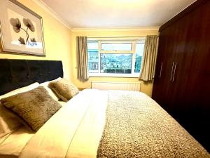 Schlafzimmer mit einem großen Bett und einem Fenster in der Unterkunft Coniston Green Holiday Home in Wetherby