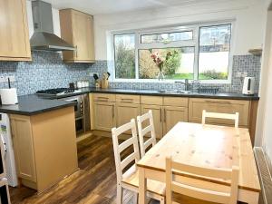 eine Küche mit einem Tisch und Stühlen sowie einem Fenster in der Unterkunft Coniston Green Holiday Home in Wetherby