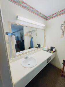 a bathroom with a sink and a mirror at Northgate Inn in Hattiesburg