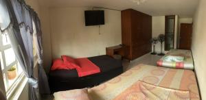 a bedroom with two beds and a television in it at Hostal Jireth in Floridablanca