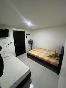 a bedroom with two beds and a fan at Hostal Jireth in Floridablanca
