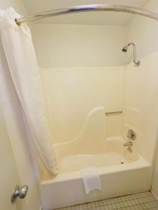 a white bath tub in a bathroom with a shower at Northgate Inn in Hattiesburg