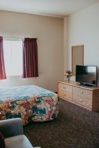 a hotel room with a bed and a flat screen tv at Carson City Plaza Hotel in Carson City