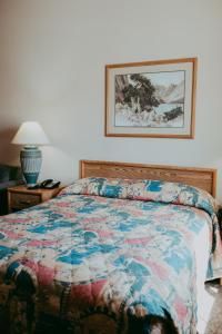 a bedroom with a bed with a quilt on it at Carson City Plaza Hotel in Carson City +43 photos
