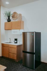 a kitchen with a stainless steel refrigerator and a sink at Carson City Plaza Hotel in Carson City