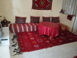 a room with a red table and a red rug at شقة المنظر الجميل in Midelt