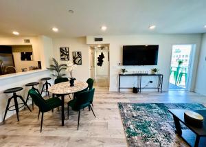 a living room with a table and chairs and a flat screen tv at Century City Cozy 2 Br 4 Sleeps Crib W Parking 505 in Los Angeles