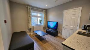a living room with a flat screen tv next to a door at Thames Ditton Surrey in Thames Ditton