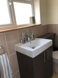 a bathroom with a white sink and a window at Iris Cottage in Whitstable +17 photos