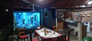 a dining room with a table and a large screen at Refúgio do Paraiso in Lucena