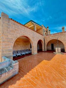 a brick wall with chairs on a patio at Villa Incina - Sea House in Polignano a Mare