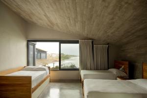 a bedroom with two beds and a large window at Casa Borrega, Luxury and Design in Higuera Blanca +37 photos