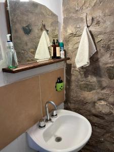 y baño con lavabo blanco y espejo. en Villa Nanin en Tilcara