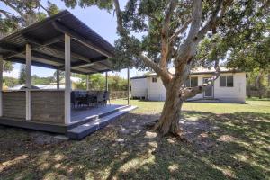 a pavilion with a table and a tree in a yard at Beach Break at Hat Head - 22 Bay St - No Sheets or Towels Provided in Hat Head