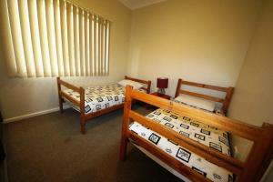 two bunk beds in a room with a window at Beach Break at Hat Head - 22 Bay Street in Hat Head