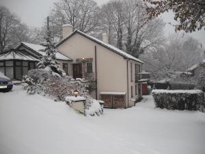 a house covered in snow with a yard at Meadfoot Guesthouse Room only accommodation for Adults in Windermere