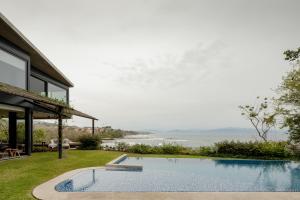 a swimming pool next to a house with a view of the water at Casa Borrega, Luxury and Design in Higuera Blanca