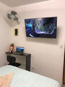 - une chambre avec un bureau et un ordinateur portable sur un mur dans l'établissement Albano: Habitación completa acústica, à Chosica