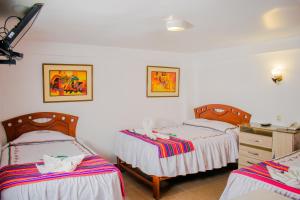 HOTEL PACHAKUTEQ في ماتشو بيتشو: غرفة نوم بسريرين وخزانة فيها
