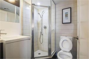 a bathroom with a shower and a toilet and a sink at Residence Inn by Soho in Toronto