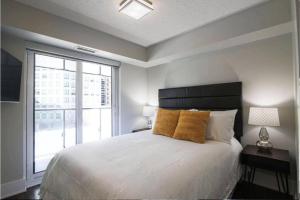 a bedroom with a large bed and a large window at Residence Inn by Soho in Toronto