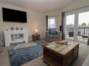 a living room with a fireplace and a flat screen tv at Cotswold Cwtch in Evesham