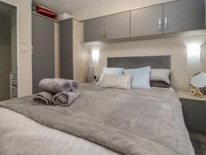 a bedroom with a large bed with towels on it at Cotswold Cwtch in Evesham