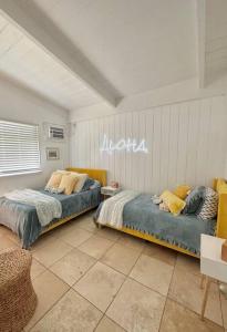 a bedroom with two beds and a sign on the wall at Moeʻuhane Kai Beach Front Home in Hauula