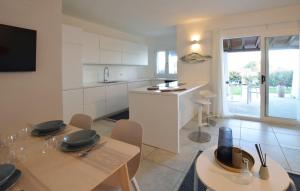 Una cocina con gabinetes blancos y una mesa y sillas. en Villa Harmony Retreat, en Budoni 20 fotos más