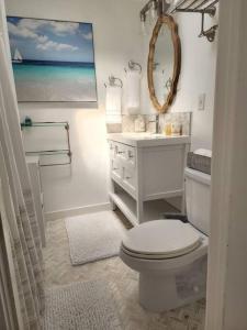 a white bathroom with a toilet and a sink at Moeʻuhane Kai Beach Front Home in Hauula +54 photos