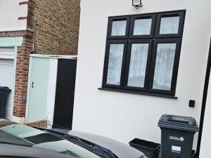 a car parked in front of a house with a window at Exeter Garden for 2 in Ilford