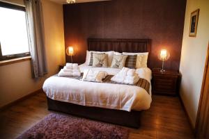 um quarto com uma cama grande e 2 candeeiros em Corncrake Cottage em Manish