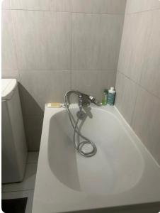 a white bath tub with a hose attached to it at Studio privatif in Goussainville
