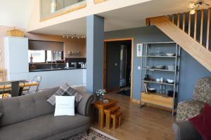 un soggiorno con divano e cucina di Otter Cottage a Manish