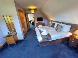 una camera da letto con un letto grande e una televisione di Otter Cottage a Manish