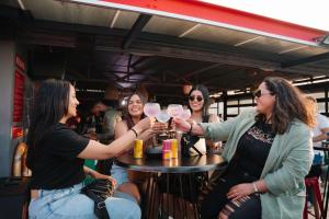 um grupo de mulheres sentadas em torno de uma mesa com copos de vinho em Radisson RED Hotel V&A Waterfront Cape Town em Cidade do Cabo