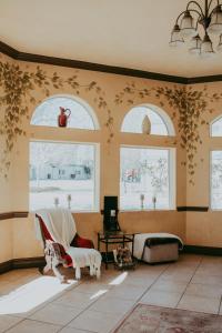 a living room with three windows and a chair at Carson City Plaza Hotel in Carson City