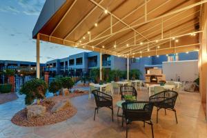 a patio with tables and chairs and a grill at Sonesta Select Scottsdale at Mayo Clinic Campus in Scottsdale